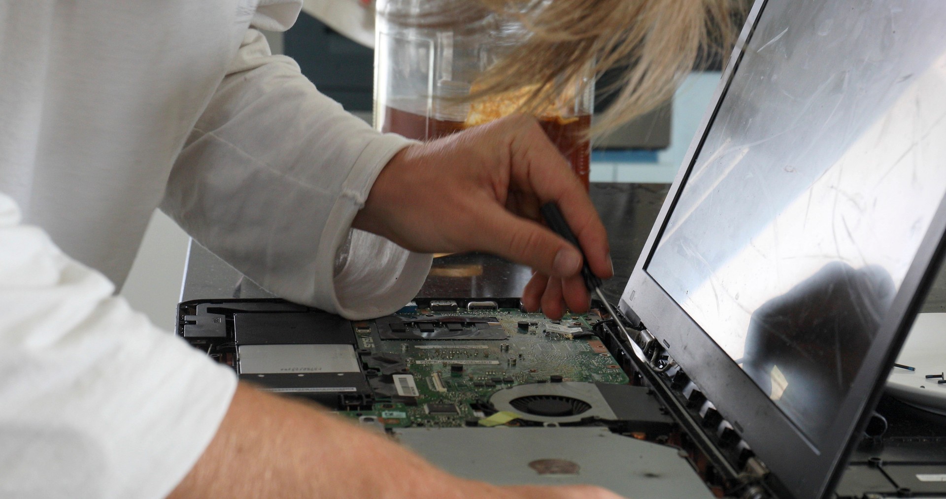 Young man dissects computer to fix it at home in the morning