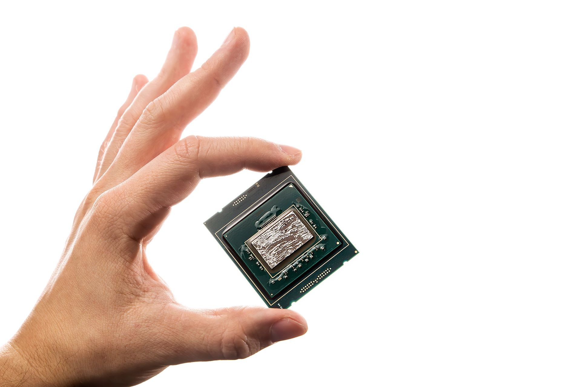 CPU with liquid metal on the crystal  in man's hand isolated on white background.